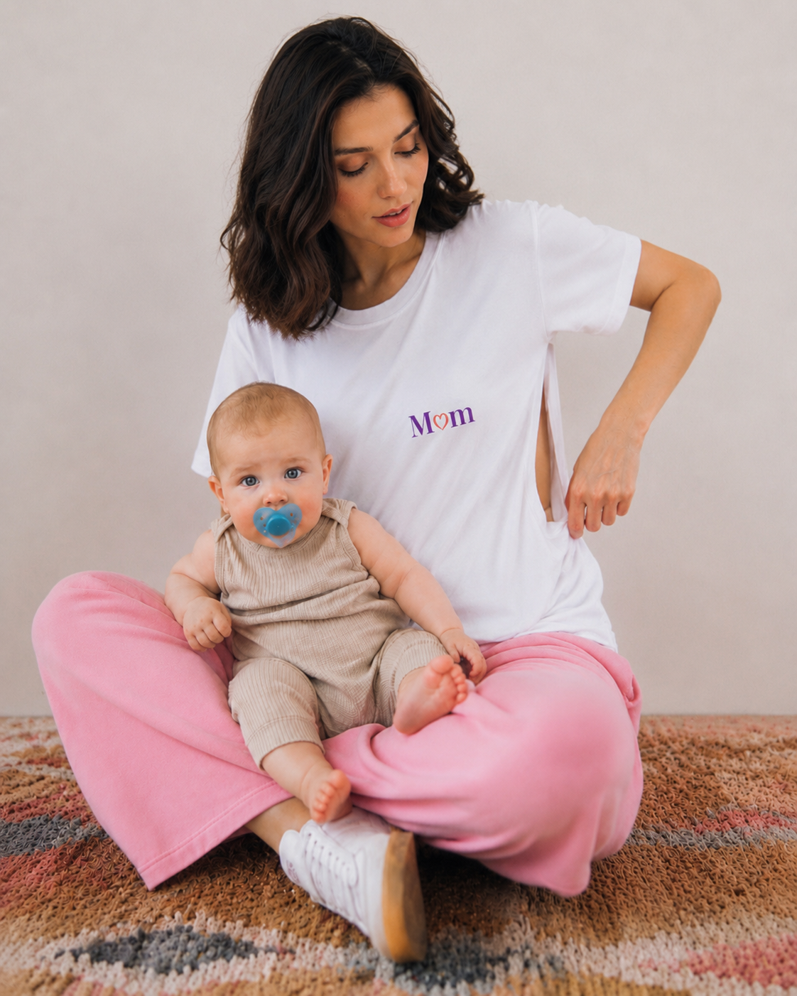 Mama mit Baby im weißen Stillshirt und pinker Hose - Stillmode von Mutterkleid
