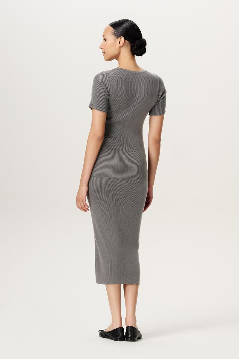 Rückenansicht mit Model des Noppies Umstandsshirt aus Feinstrick. Zu mieten oder kaufen bei Mutterkleid.