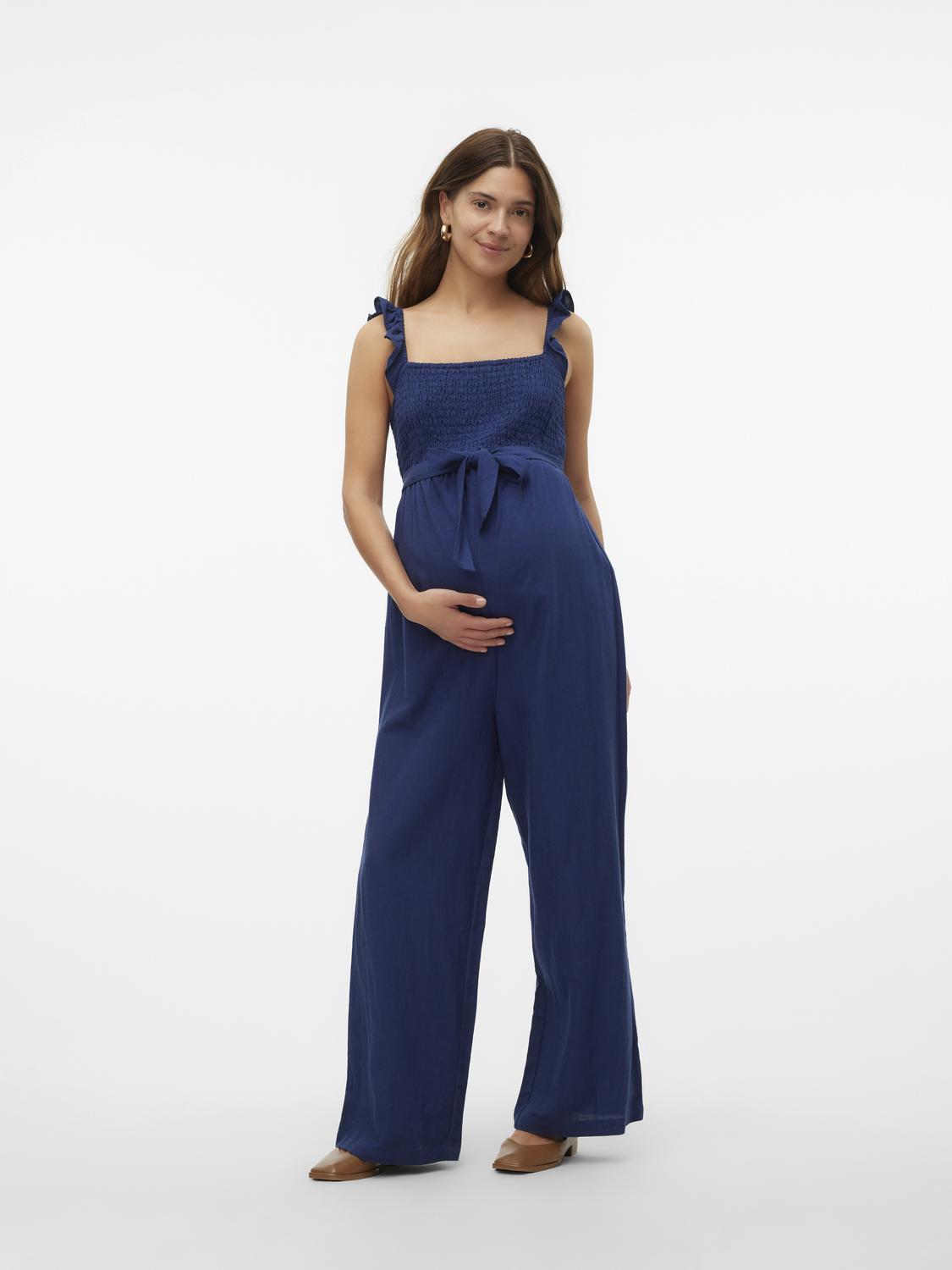 Dunkelblauer Mamalicious Jumpsuit wird von Model von vorne gezeigt. Bei Mutterkleid kaufen oder mieten.