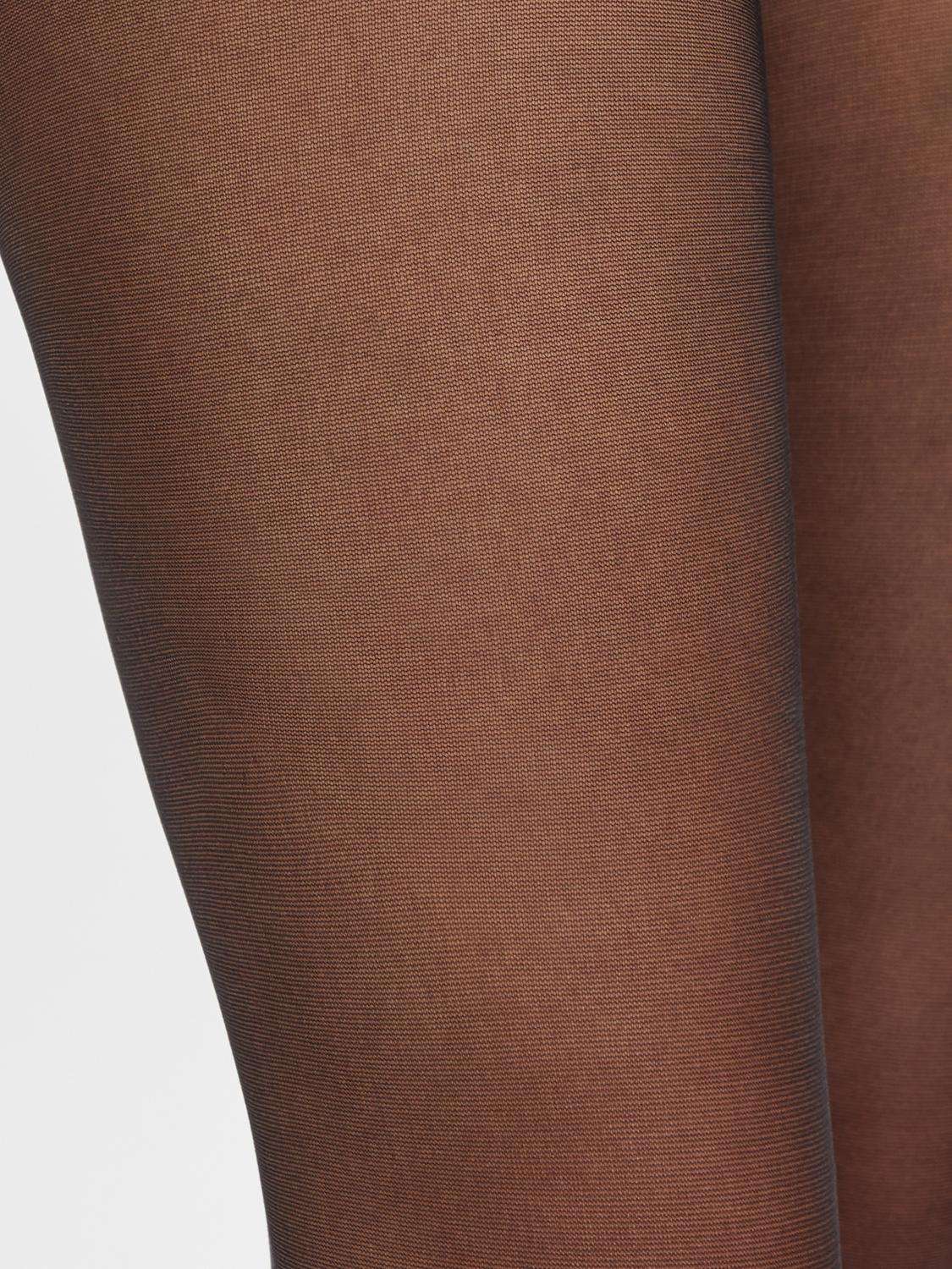 Beine in schwarzen Umstandsstrumpfhose, Nahaufnahme. Bei Mutterkleid shoppen