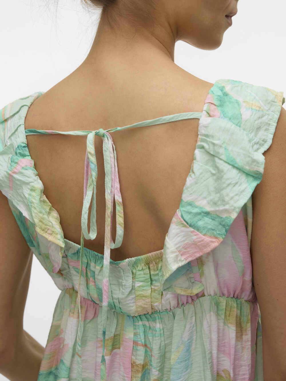 Model zeigt im Detail Rückenansicht von dem Vero Moda Maternity Maxi Umstandskleid in Pastelfarben. Bei Mutterkleid.de