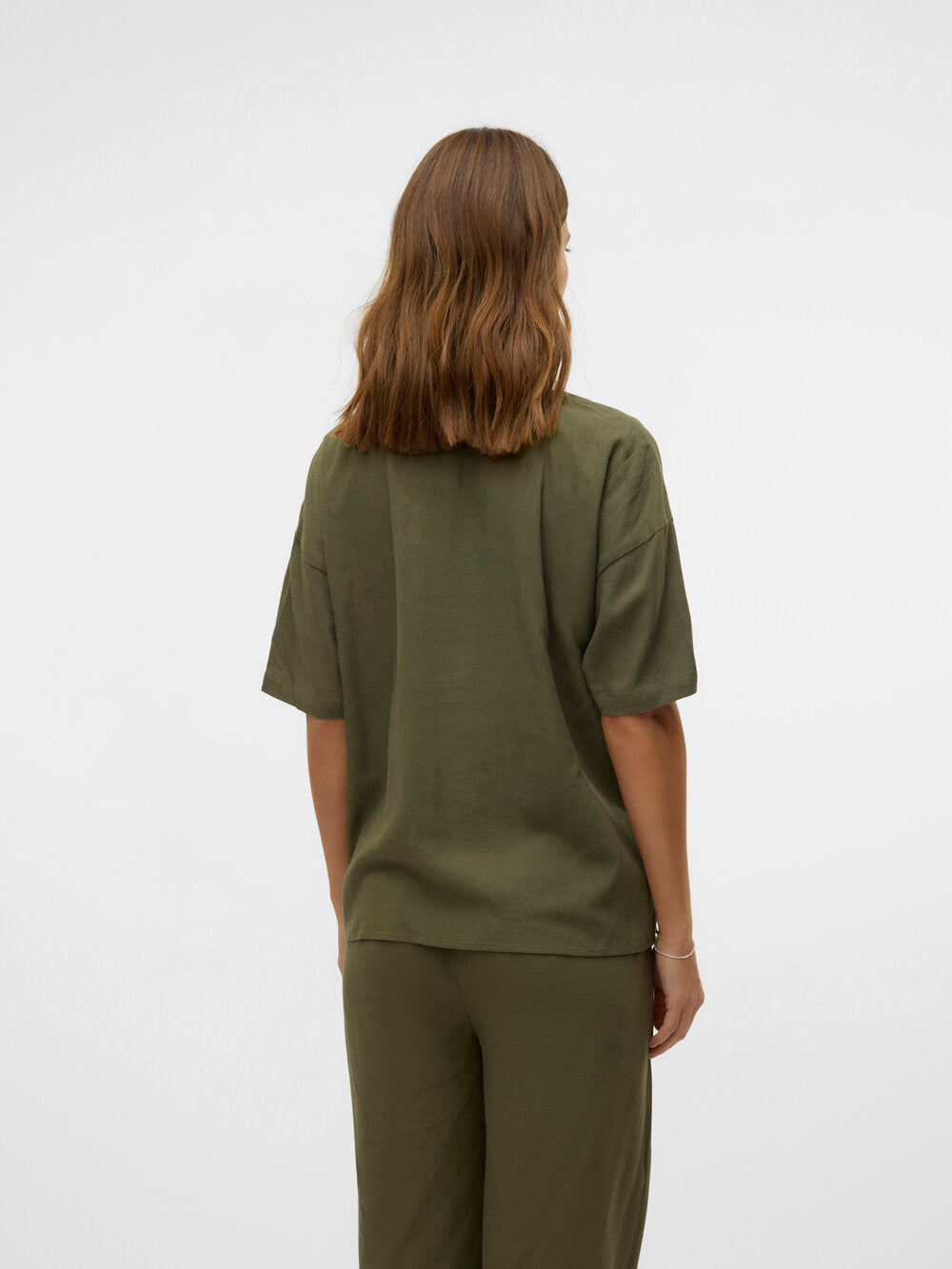 Brünettes Model zeigt Vero Moda Maternity Umstandsblus von hinten. Im Mutterkleid Store erhältlich.