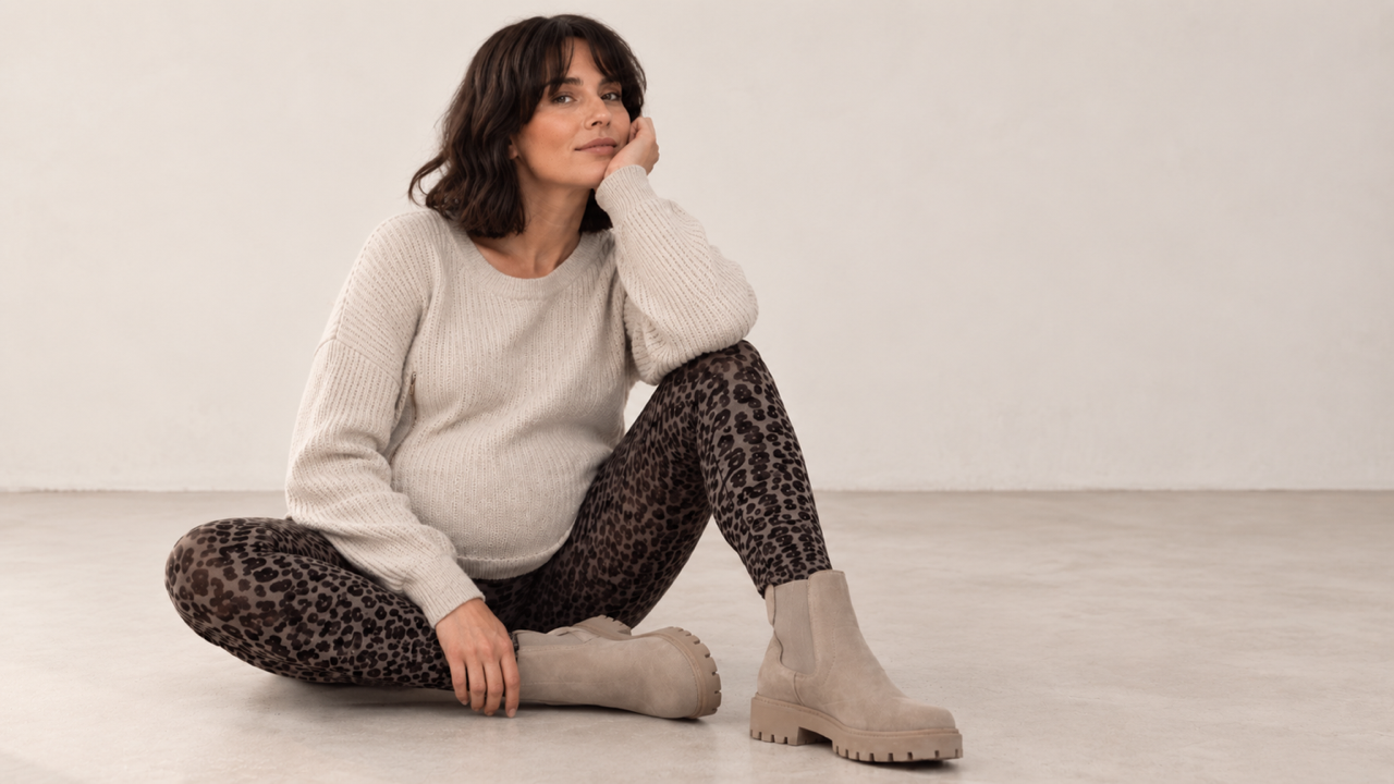 Schwangere Frau in Leo Umstandsleggings und beigem Strickpullover. Herbst Styles für Schwangerschft und Stillzeit