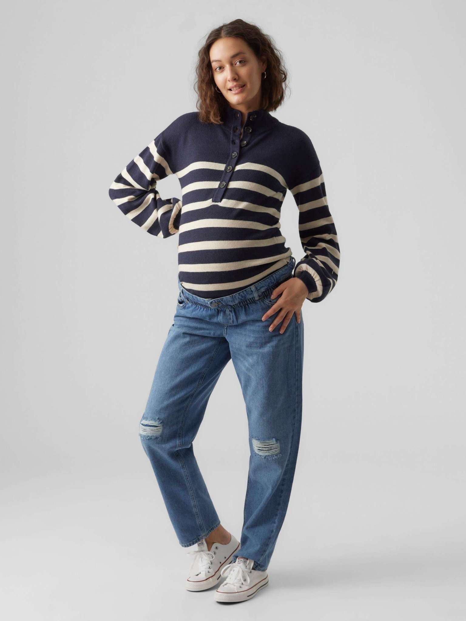 Model zeigt in lässiger Pose den Mamalicious Umstandspullover in blau weiss gestreift mit Umstandsjeans von vorne. Erhältlich zum Kaufe oder Miete bei Mutterkleid