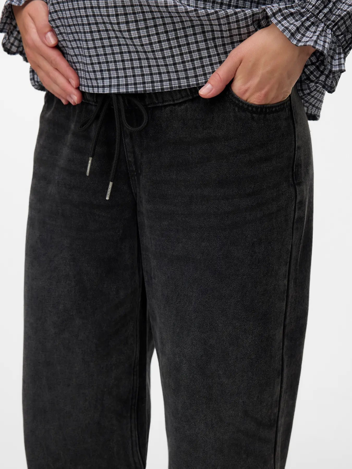 Detailaufnahme. Frau mit Babybauch und weiter Jeans im Biggy-Style. Kaufe oder miete online bei Mutterkleid 