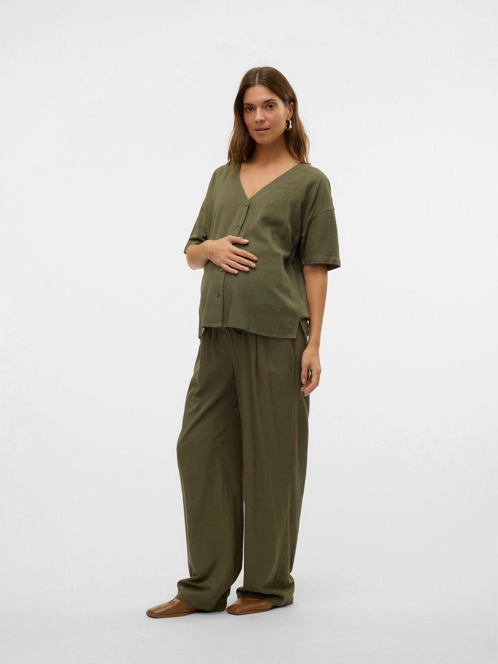 Model zeigt in ganzkörperaufnahme die Umstandsbluse Stillbluse  von Vero Moda Maternity in grün. Bei Mutterkleid kaufen oder mieten