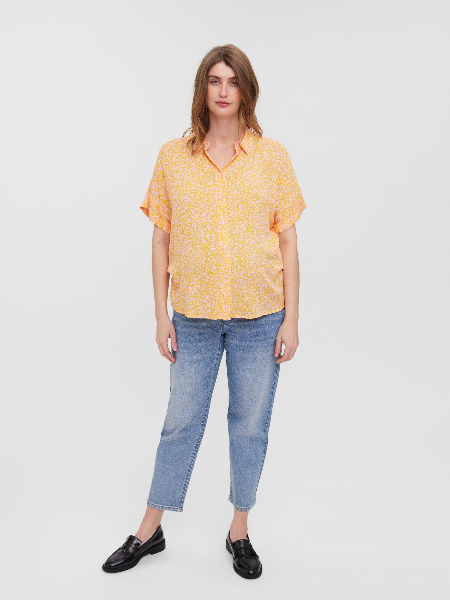 Bruenettes Model zeigt in Ganzkörperansicht Umstandsbluse kurzarm aus Viskose in orange/rosa mit Knöpfen für das Stillen von Vero Moda Maternity bei Mutterkleid online kaufen oder mieten